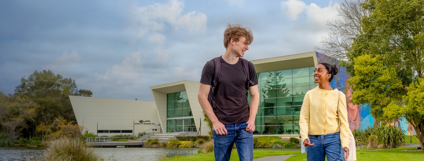 Male and female student walking outside in the college campus
