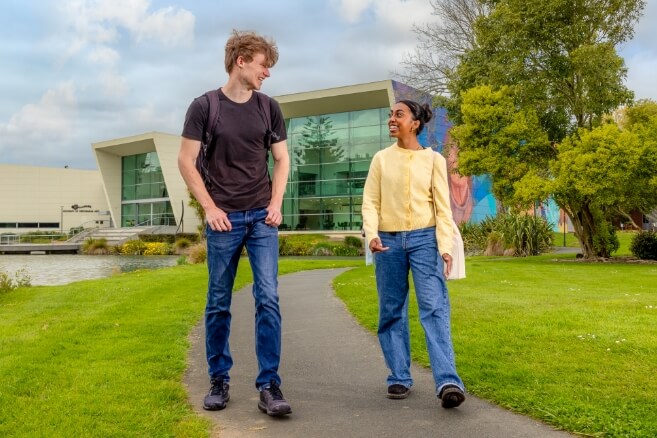 Male and female student walking outside in the college campus