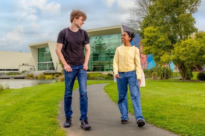 Male and female student walking outside in the college campus