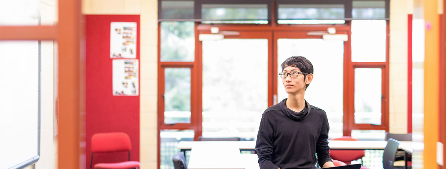 Person holding laptop in classroom