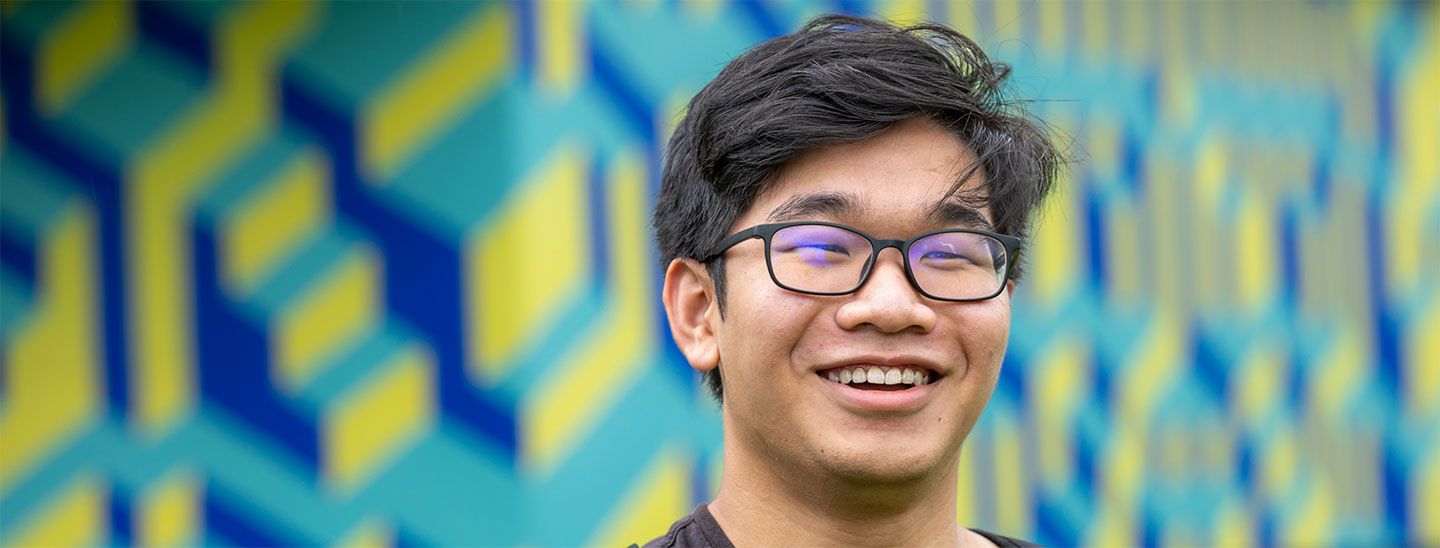 Student happy outside against colorful wall