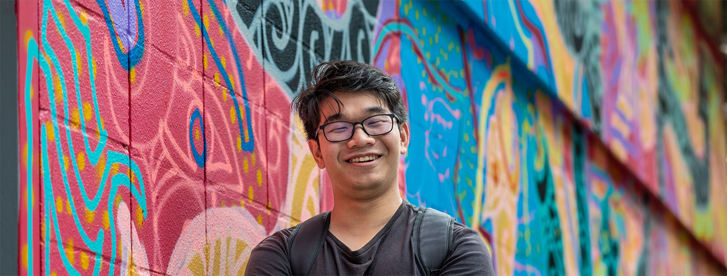 Student in front rainbow wall