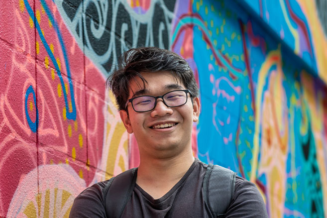 Student in front rainbow wall