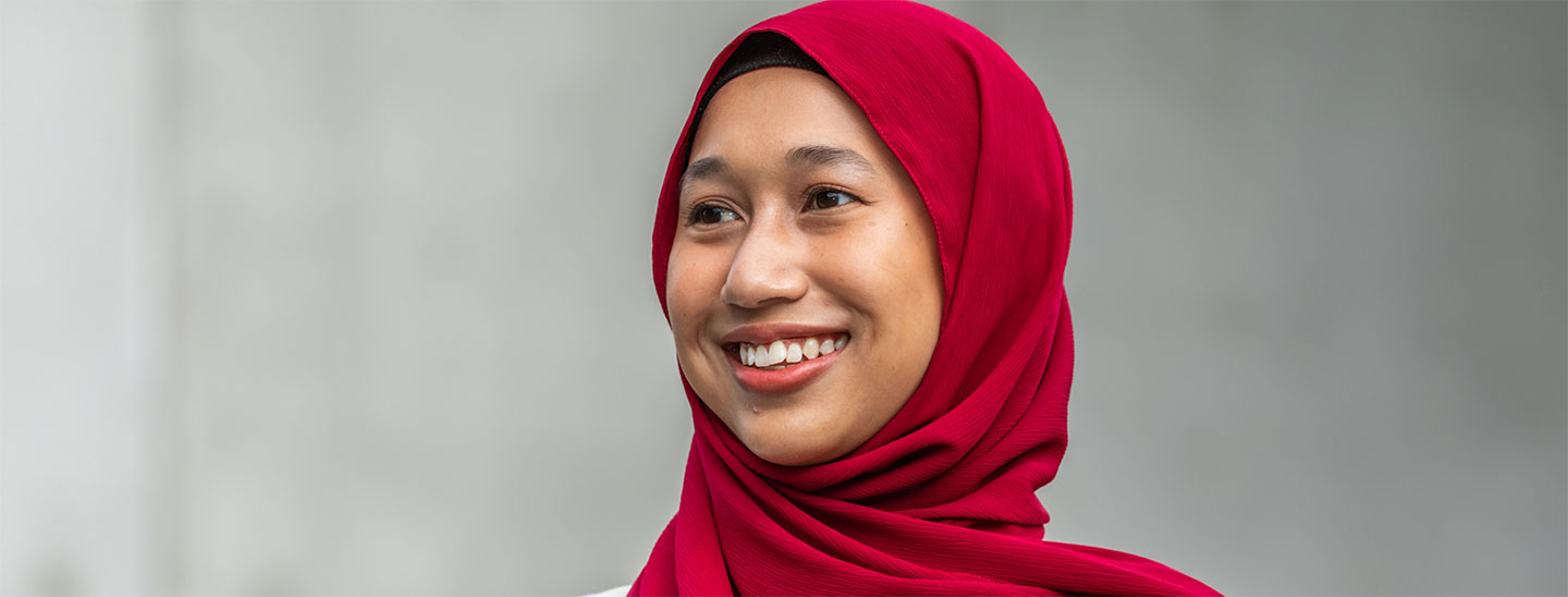 Student outside red burqa