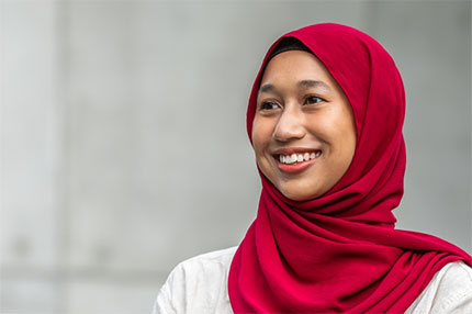 Student outside red burqa