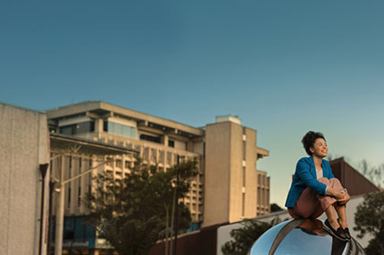 Student sitting on sculpture