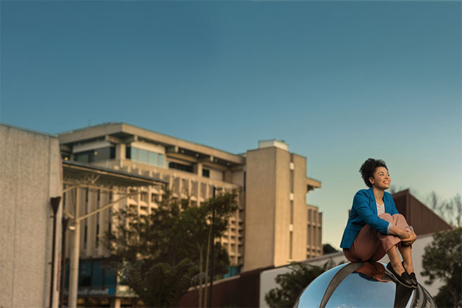 Student sitting on sculpture